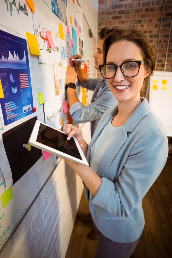 business-executives-using-digital-tablet-writing-sticky-notes